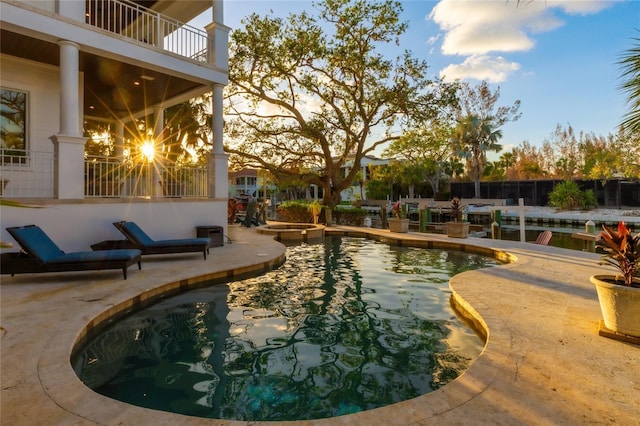 pool at dusk with a patio