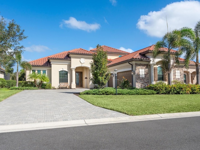 mediterranean / spanish-style house with a garage and a front lawn