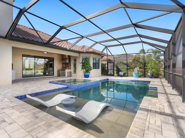 view of swimming pool with an in ground hot tub, a lanai, an outdoor kitchen, and a patio