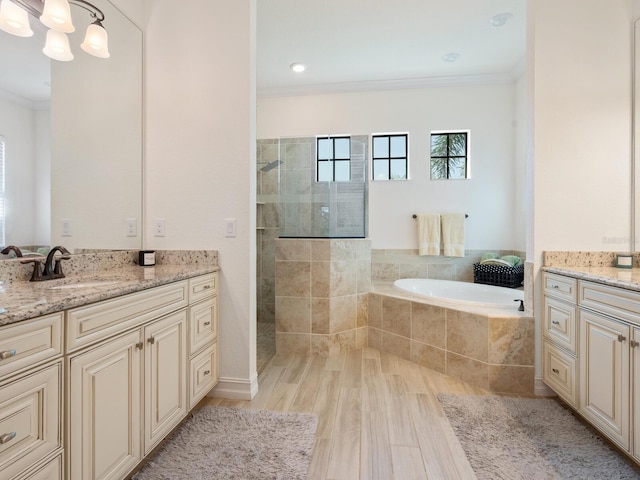 bathroom with vanity, ornamental molding, shower with separate bathtub, and an inviting chandelier