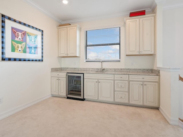 kitchen with sink, crown molding, cream cabinets, light carpet, and beverage cooler