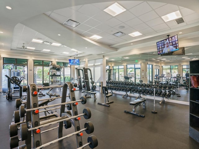 gym with plenty of natural light and a paneled ceiling