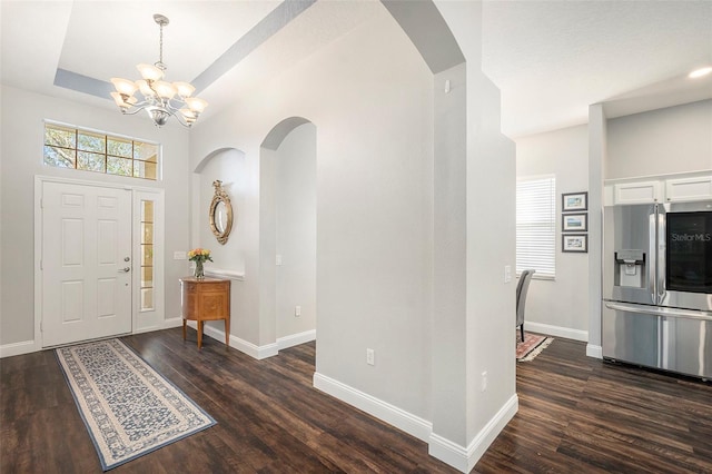 foyer entrance featuring dark hardwood / wood-style floors and a notable chandelier