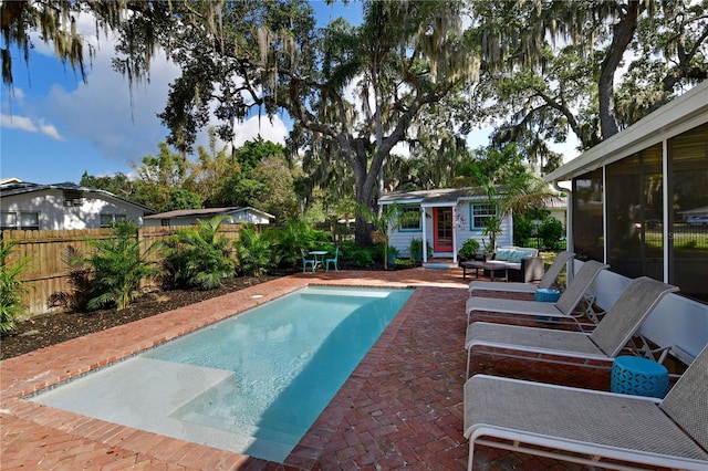 view of swimming pool with a patio and a sunroom