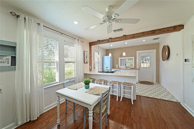 dining room featuring dark hardwood / wood-style floors, sink, a wealth of natural light, and beam ceiling