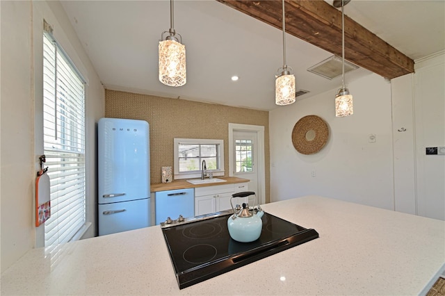 kitchen with white appliances, beam ceiling, sink, and hanging light fixtures