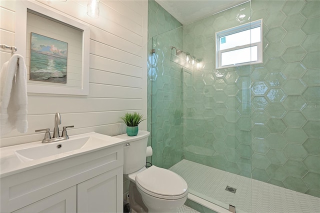 bathroom featuring vanity, a tile shower, wood walls, and toilet