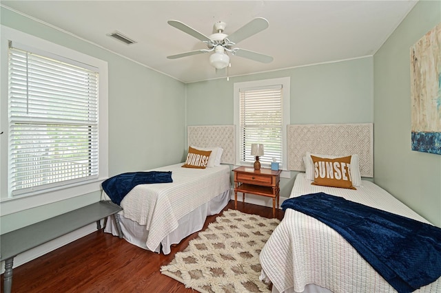 bedroom with dark hardwood / wood-style flooring and ceiling fan