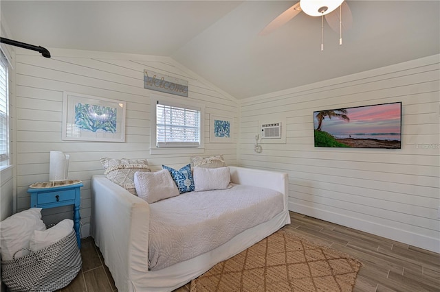 bedroom with lofted ceiling, a wall unit AC, ceiling fan, and wood walls