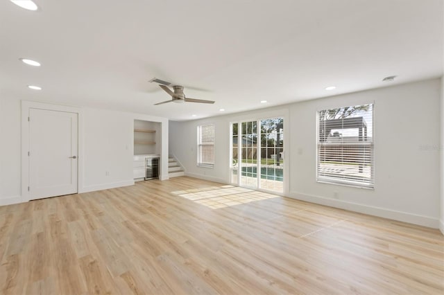 unfurnished living room with light wood-type flooring and ceiling fan