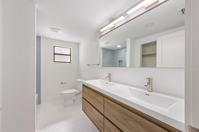 bathroom with toilet, vanity, and tile patterned floors