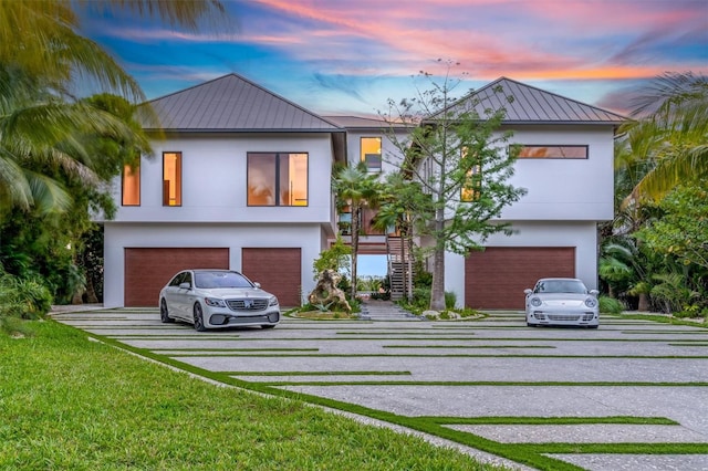 view of front of house featuring a garage and a lawn