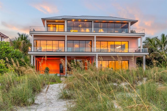 back house at dusk with a balcony