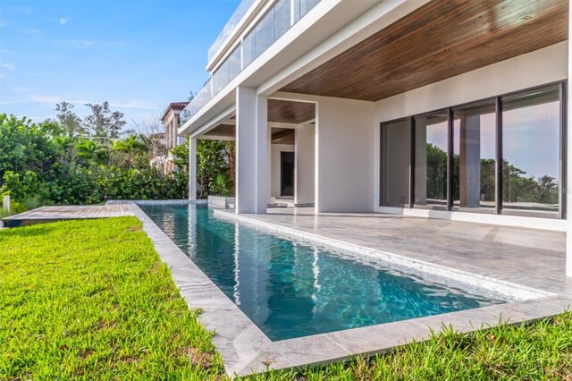 view of swimming pool featuring a patio area and a lawn