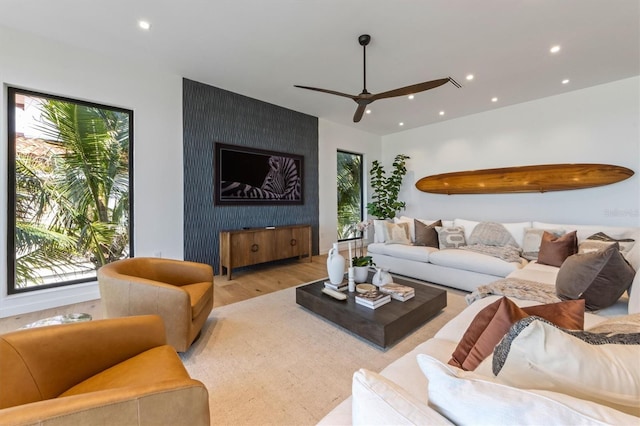 living room featuring ceiling fan and light hardwood / wood-style flooring