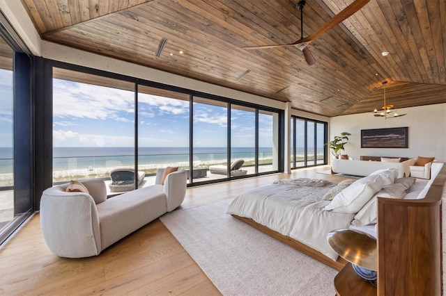 bedroom with lofted ceiling, a water view, multiple windows, and wooden ceiling