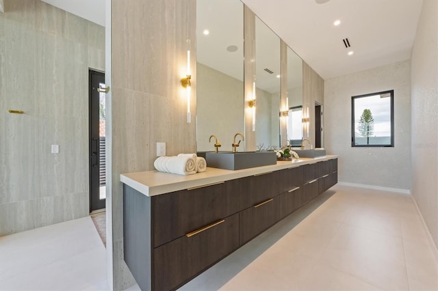 bathroom with tile patterned flooring, vanity, and tile walls