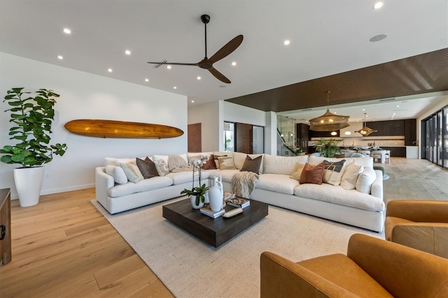 living room featuring light wood-type flooring and ceiling fan