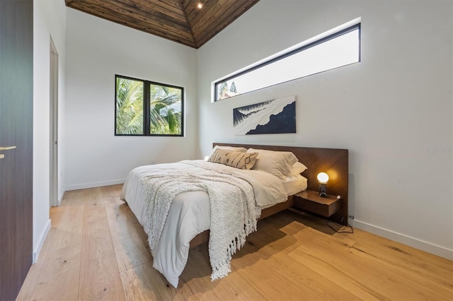 bedroom with light hardwood / wood-style flooring and high vaulted ceiling