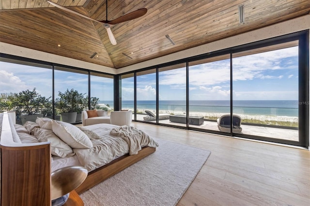 bedroom with light wood-type flooring, wood ceiling, a beach view, and a water view