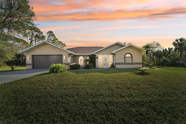 ranch-style home with a garage and a lawn