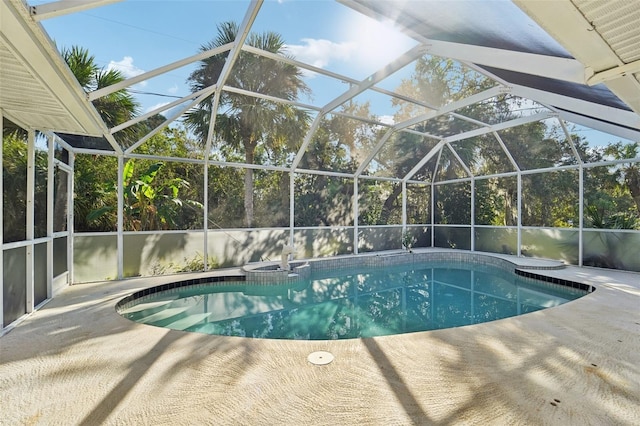 view of swimming pool with glass enclosure and a patio area