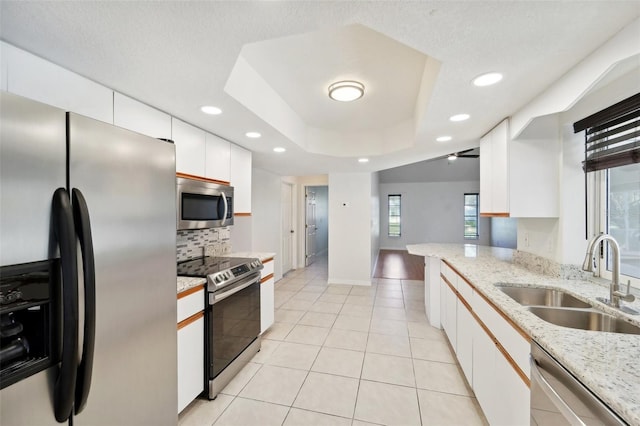 kitchen with stainless steel appliances, plenty of natural light, sink, and white cabinets