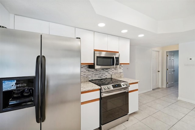 kitchen featuring white cabinetry, decorative backsplash, stainless steel appliances, and light tile patterned floors