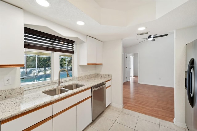 kitchen with light stone counters, light hardwood / wood-style flooring, sink, white cabinetry, and appliances with stainless steel finishes