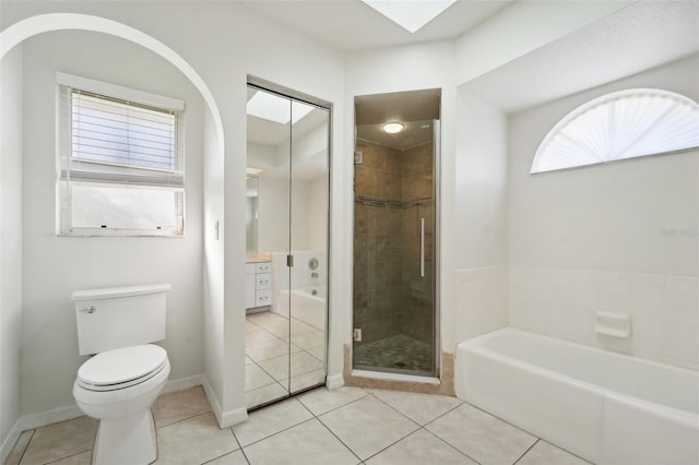 bathroom featuring tile patterned flooring, shower with separate bathtub, a skylight, and toilet