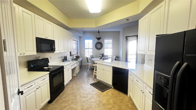 kitchen featuring sink, black appliances, kitchen peninsula, light tile patterned floors, and white cabinets