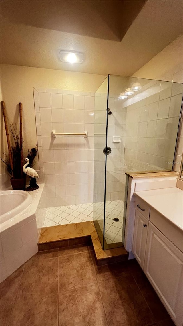 bathroom with tile patterned flooring, vanity, and separate shower and tub