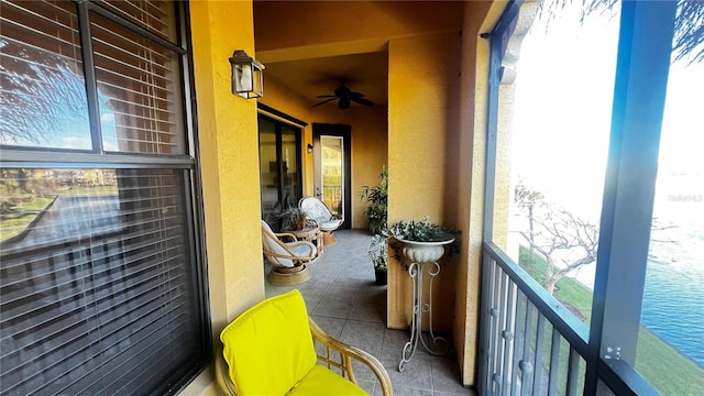 balcony with a water view and ceiling fan