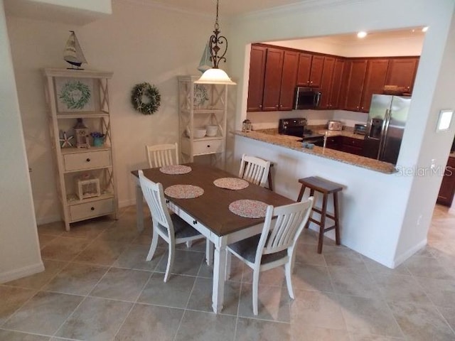 tiled dining area featuring crown molding