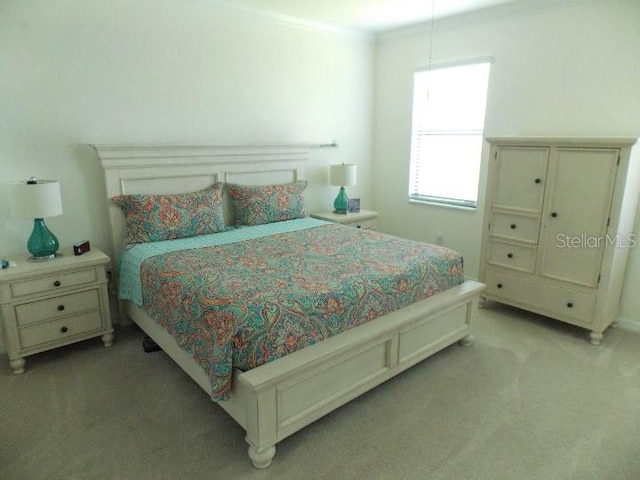 bedroom featuring light colored carpet and ornamental molding