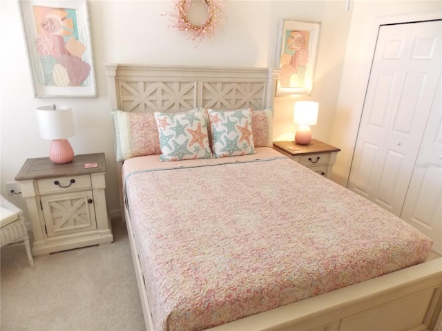 bedroom featuring light colored carpet and a closet