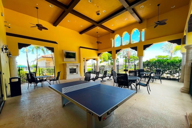 rec room with beamed ceiling, ceiling fan, plenty of natural light, and coffered ceiling