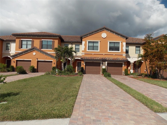 mediterranean / spanish home featuring a front lawn and a garage