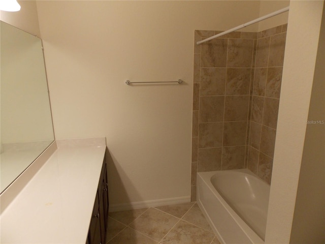 bathroom featuring tile patterned flooring, vanity, and tiled shower / bath