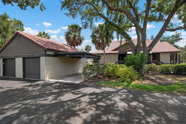 view of front of house with a garage, a tiled roof, and stucco siding