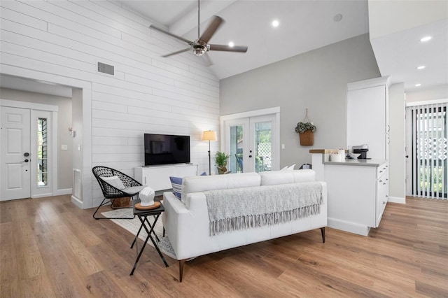 living room featuring high vaulted ceiling, light wood finished floors, and a wealth of natural light