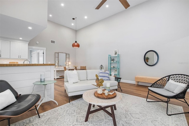 living room with hardwood / wood-style flooring and high vaulted ceiling