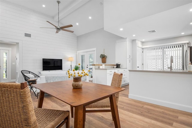 dining space with french doors, light hardwood / wood-style floors, high vaulted ceiling, beamed ceiling, and ceiling fan