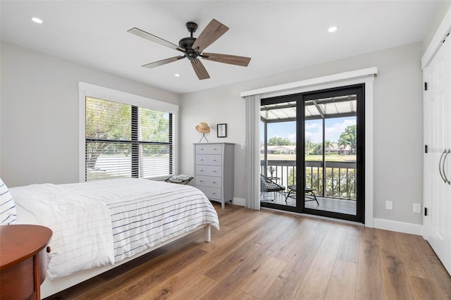 bedroom with access to exterior, baseboards, wood finished floors, and recessed lighting