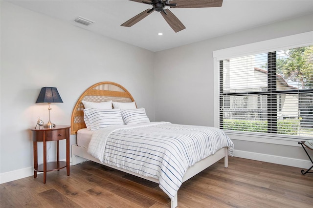 bedroom featuring visible vents, baseboards, and wood finished floors