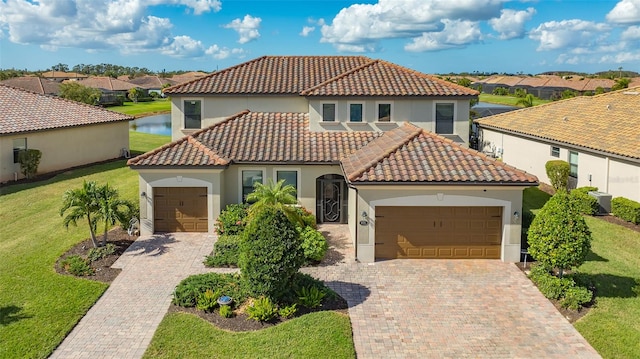 mediterranean / spanish-style house featuring an attached garage, a front lawn, decorative driveway, and stucco siding