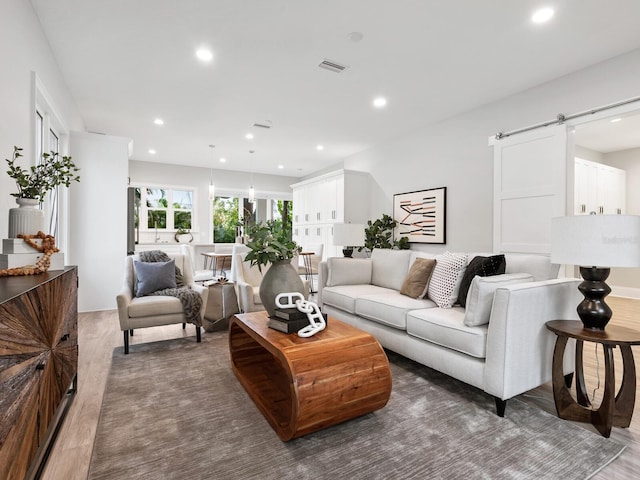 living room featuring a barn door and dark hardwood / wood-style flooring