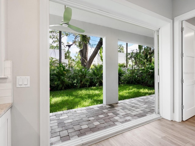 doorway featuring light wood-type flooring and ceiling fan