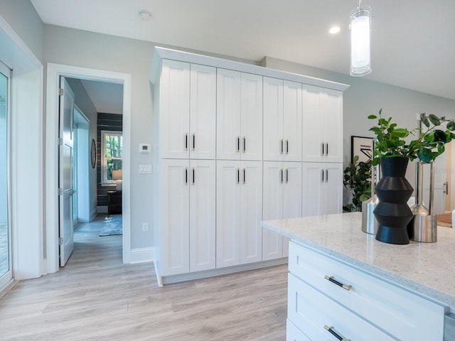 kitchen with light hardwood / wood-style floors, white cabinetry, and pendant lighting