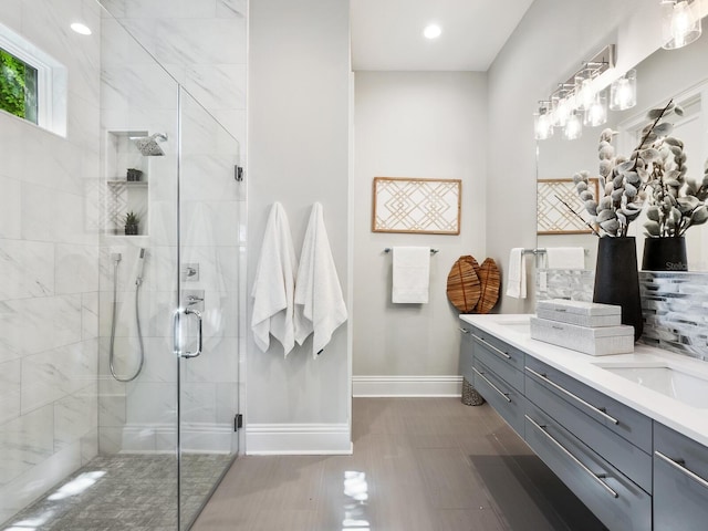 bathroom featuring vanity and a shower with door